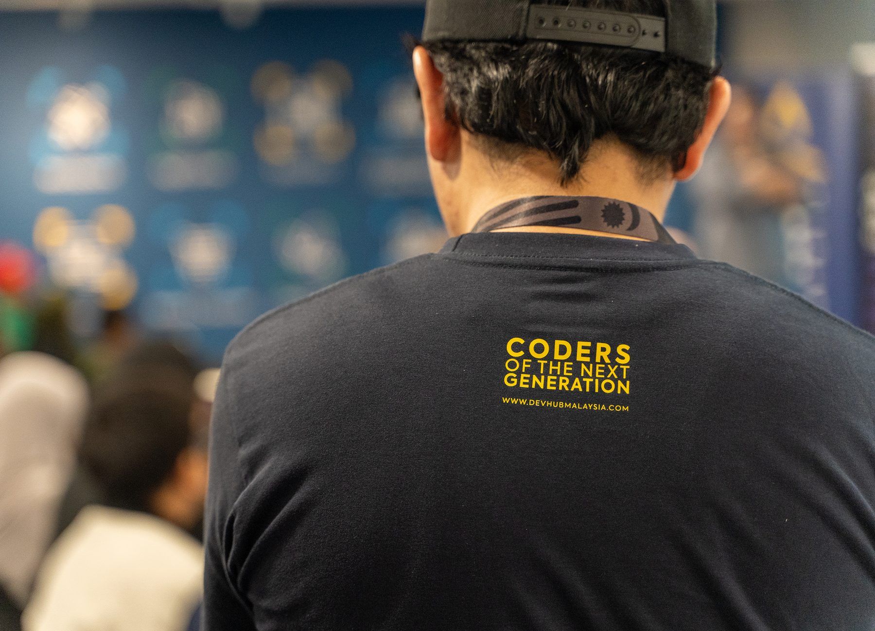 An attendee wearing a "Coders of the Next Generation" shirt